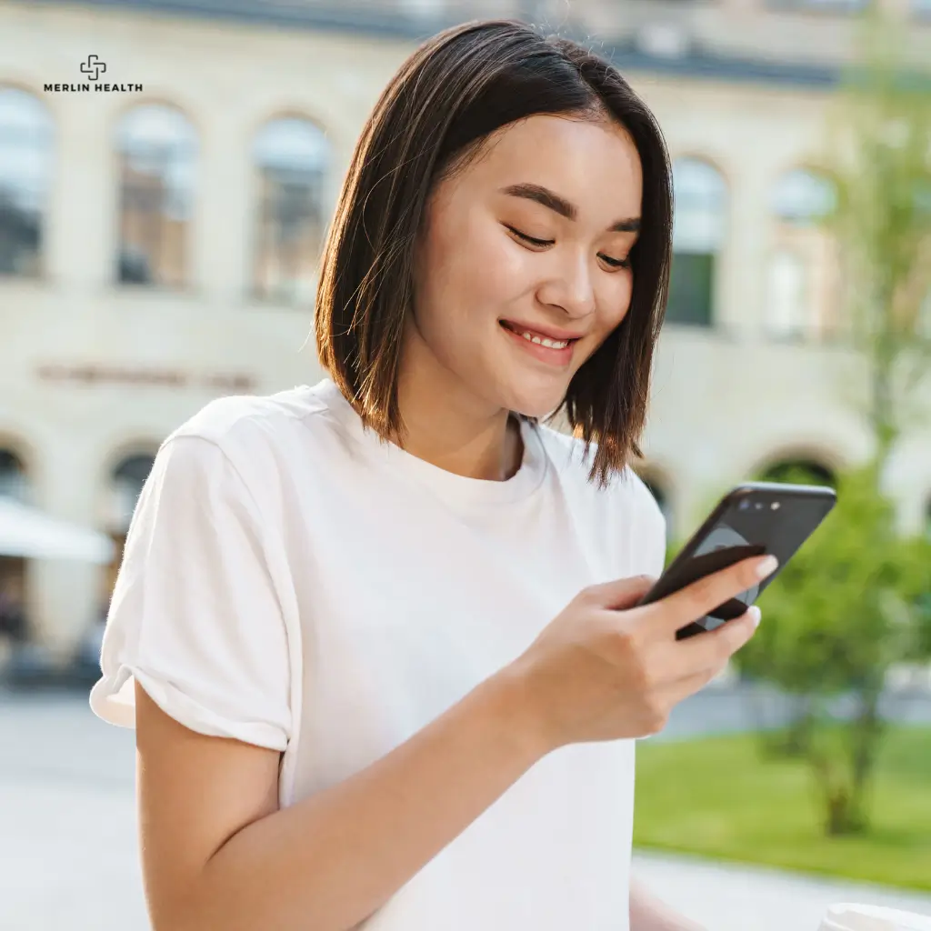 A lady looking at her mobile phone after receiving a same-day online medical certificate in the UK from Merlin Health.